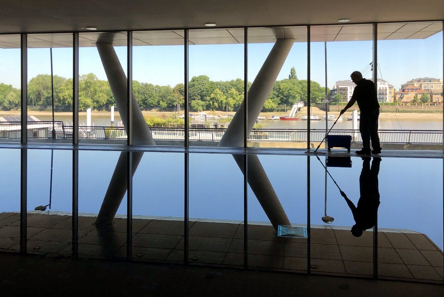 A Rodal operative treating a poolside floor at a riverside leisure building